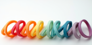 Bracelets en caoutchouc colorés alignés sur fond blanc