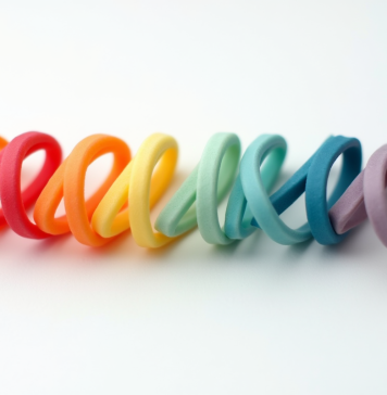 Bracelets en caoutchouc colorés alignés sur fond blanc