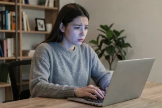 Jeune femme préoccupée devant un ordinateur portable, illustrant les enjeux de vie privée et de fuites de données en ligne